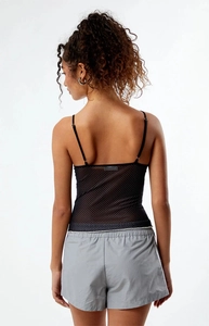 Detail of sheer black polka dot camisole with thin straps and grey sporty shorts set
