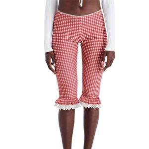 Detail of red gingham cropped leggings featuring ruffled hem and delicate white lace trim