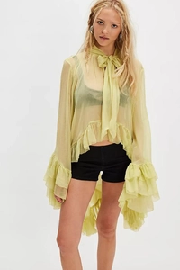 Close-up of light green sheer chiffon blouse featuring delicate ruffles and bow tie
