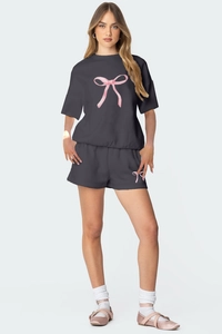 Détail de l'ensemble décontracté gris avec imprimés nœuds roses sur le t-shirt et le short