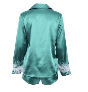 Detail view of emerald green satin pajama set back with white feather sleeve cuffs