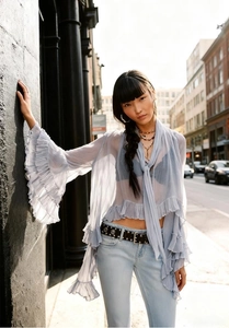 Detail of light blue sheer chiffon top with layered ruffles and wide flare bell sleeves