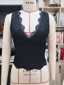Dettaglio della trama in pizzo nero e scollo a V su un top sottoveste aderente chic