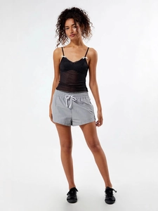 Women's black polka dot mesh camisole with bows and grey shorts set in a studio shot