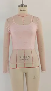 Detailed view of pink lace long sleeve top with bow pattern and matching camisole set