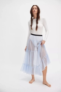 Detail of light blue tiered mesh skirt with white flocked heart polka dots and black waist