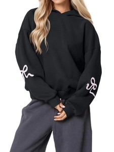Oversized black hoodie for women featuring pink ribbon bow prints on long sleeves