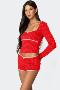 Detailansicht der roten gepunkteten Loungewear mit weißem Spitzenbesatz und Schleife