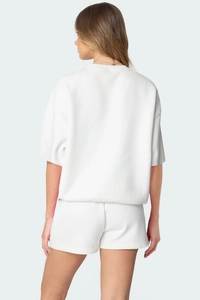 Vue arrière d'un ensemble détente blanc deux pièces avec sweat-shirt et short assortis