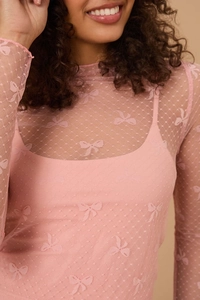 Detail of pink mesh long-sleeve top with bow patterns and matching inner camisole