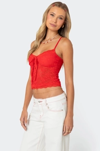 Détail d'un bustier en dentelle rouge avec nœud en satin et bordure en dentelle cil