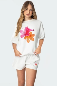 Détail de l'imprimé floral rose et orange sur un ensemble d'été en coton blanc doux