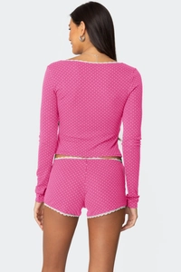 Detailaufnahme von rosa Polka-Dot-Loungewear mit Spitzenbesatz und Rippstrick-Textur