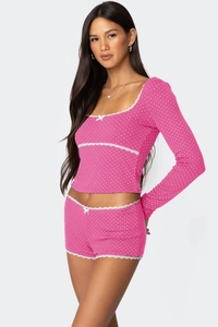 Detail eines rosa Polka-Dot-Lounge-Sets mit weißer Spitze und kleinen Schleifen am Saum