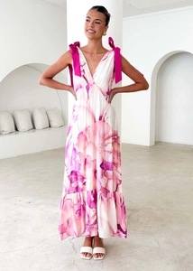 Detailed view of the deep V-neckline and magenta bow shoulder straps on a floral dress