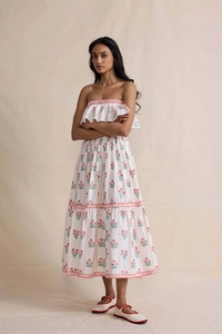 Close-up of elegant floral print and ruffled layers on white strapless maxi dress