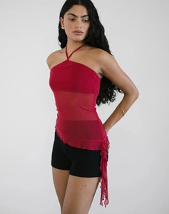 Détail du haut dos nu en tulle rouge avec ourlet à volants irrégulier et tissu voilé