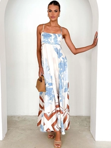 Floral print halter A-line maxi dress with patchwork hem in a sunny outdoor setting
