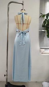 Detail of light blue satin evening gown featuring a halter neck and rear bow design