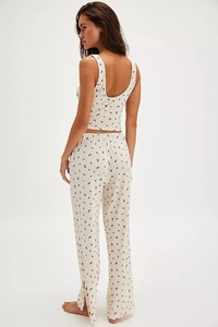 Detailed close-up of side slit and button accents on floral pajama pants hemline