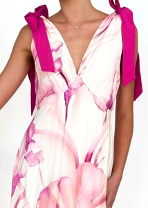 Detail of pink floral print dress featuring V-neckline and magenta shoulder ribbon bows