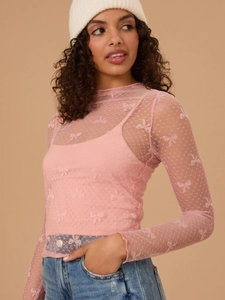 Detail of pink sheer mesh long sleeve top with bow patterns and inner camisole