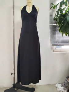 Detail view of black satin halter neck maxi dress with V-neckline on a mannequin