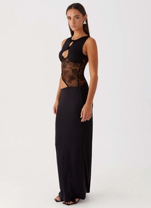 Detail of elegant black sleeveless maxi dress featuring lace patchwork and side cutouts