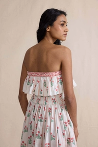 Detailed view of smocked floral dress with elegant ruffles and red flower prints