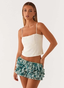 Detailed view of white square neck camisole and layered floral ruffled mini skirt
