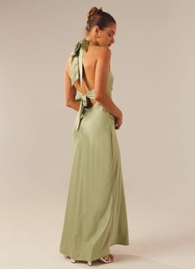 Detail of sage green satin evening dress featuring an open back with a large bow tie