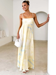 Elegant floral print backless maxi dress with thin straps in a minimalist indoor setting