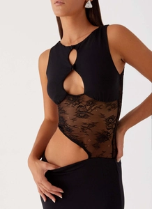 Close-up of black bodycon dress featuring intricate floral lace inserts and teardrop cutout