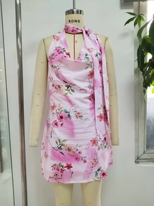 Détail de la robe licou rose à fleurs avec décolleté en V profond et écharpe en mousseline