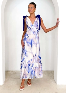 Detail of floral V-neck maxi dress with navy blue bow shoulder straps and tiered hem