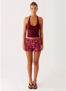 Detail of pink floral tiered ruffle shorts with lace edges and dark red halter top outfit
