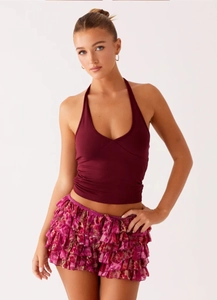 Detail of pink leopard print tiered ruffles and burgundy halter top on a fashion set