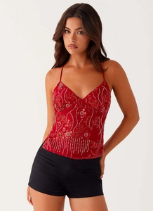 Gros plan du haut licou rouge avec des broderies complexes de paillettes et perles