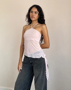 Détail du haut dos nu en maille rose clair avec ourlet à volants asymétrique et tissu pur