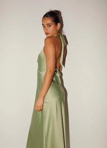 Detail of light green satin dress featuring a halter neck and open back with bow tie