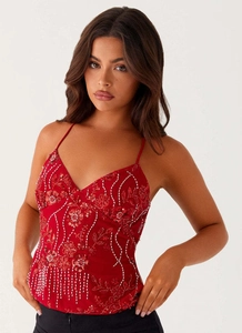Détails de la broderie florale à paillettes rouges et franges perlées sur le caraco