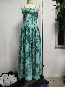 Detail view of turquoise floral strapless maxi dress with pleats on a mannequin