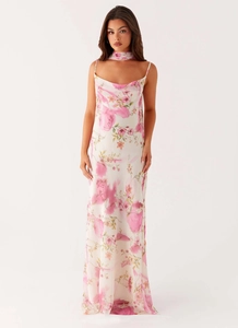 Détail d'une robe longue fleurie dos nu avec écharpe assortie et décolleté drapé élégant