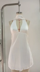 Close-up of white satin mini dress with deep V-neck and backless design on mannequin