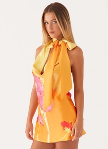 Détail de robe dos nu à fleurs avec grand nœud en satin au cou et imprimé floral orange