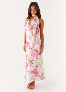 Detail of floral halter dress with vibrant watercolor patterns on silky satin fabric