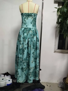 Detail of teal bohemian strapless maxi dress with deep green botanical floral patterns