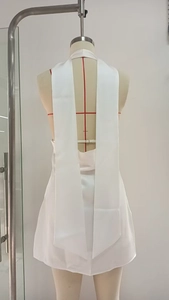 Detailed back view of white satin halter dress with elegant ribbon tie and open back