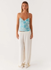 Détail du haut dos nu bleu clair avec broderie florale bleue et perles blanches délicates