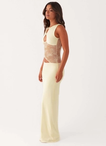 Detail of water-drop cutout and floral lace patchwork on pale yellow slim maxi dress